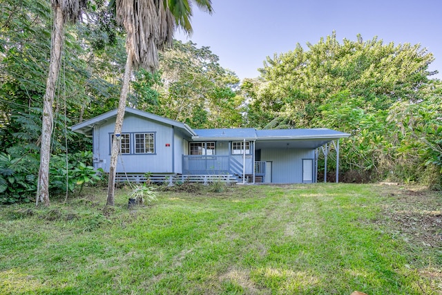 back of house featuring a carport, covered porch, and a lawn