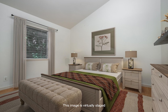 bedroom with lofted ceiling and light wood-type flooring