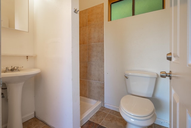 bathroom featuring sink, toilet, tile patterned flooring, and tiled shower