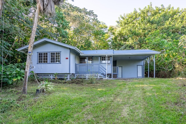 back of property with a lawn, a porch, and a carport