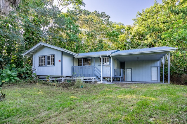 back of property featuring a lawn, covered porch, and a carport