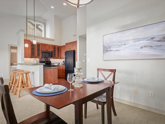 dining area with baseboards, a high ceiling, visible vents, and recessed lighting