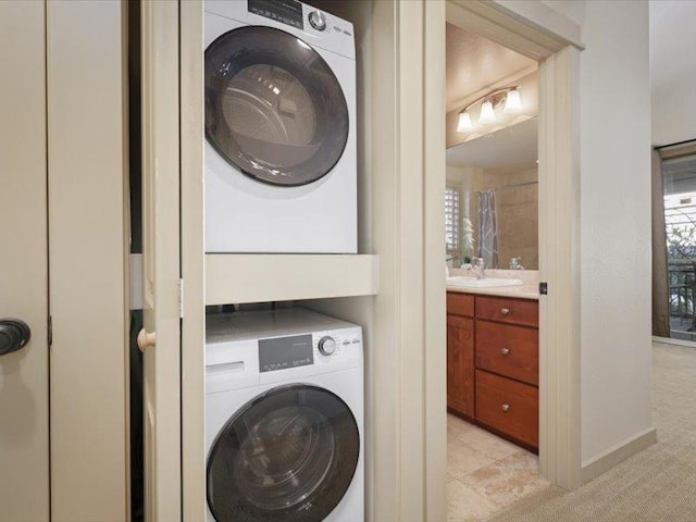 laundry room featuring light carpet, laundry area, a sink, and stacked washer / drying machine