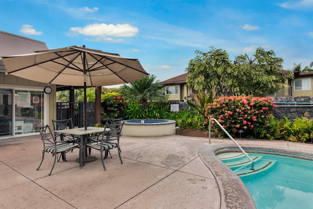 pool featuring outdoor dining area, a patio area, a jacuzzi, and fence