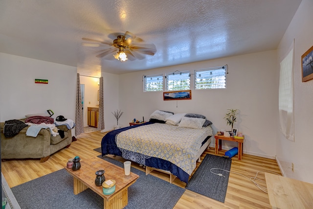 bedroom featuring a textured ceiling, wood-type flooring, and ceiling fan