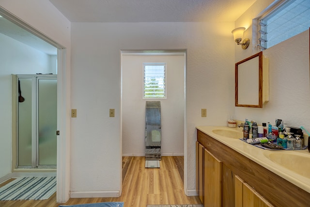 bathroom with vanity, a textured ceiling, walk in shower, and wood-type flooring