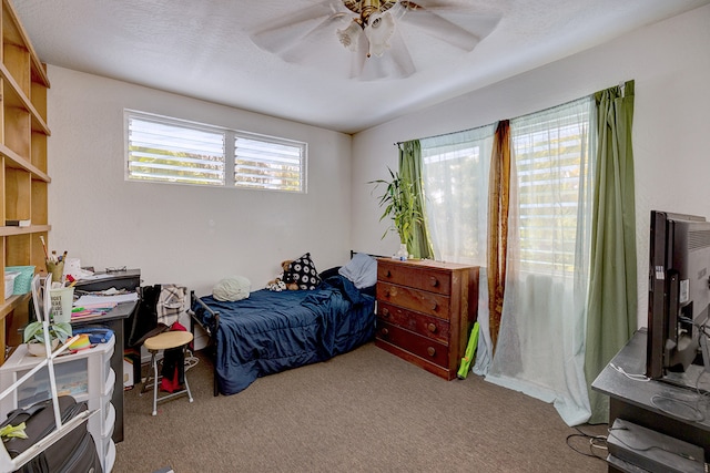 carpeted bedroom with a textured ceiling and ceiling fan