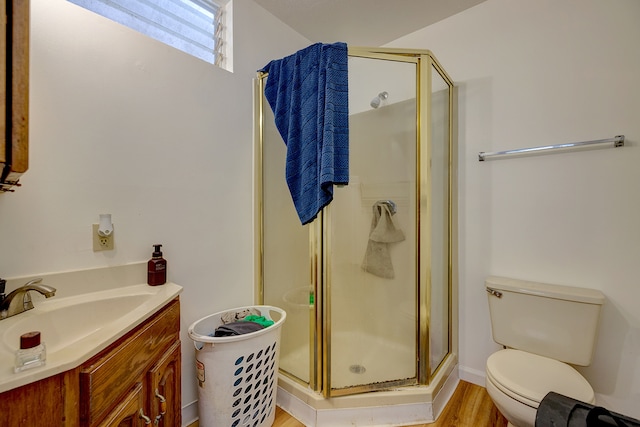 bathroom with a shower with door, vanity, hardwood / wood-style flooring, and toilet