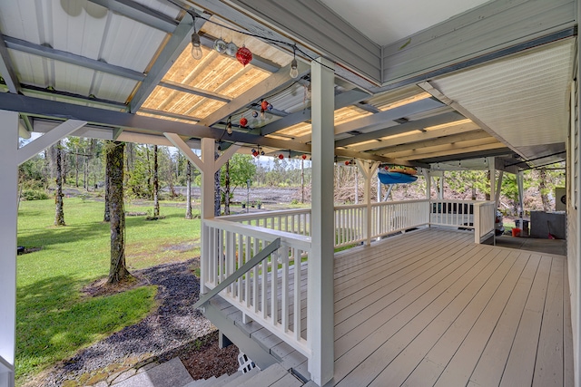 wooden terrace with ceiling fan and a lawn