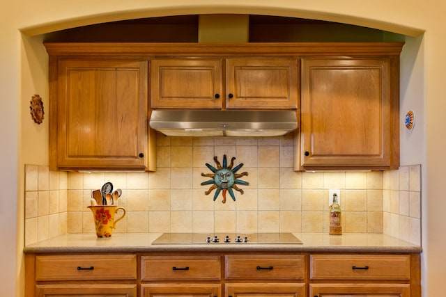 kitchen with black electric cooktop and tasteful backsplash