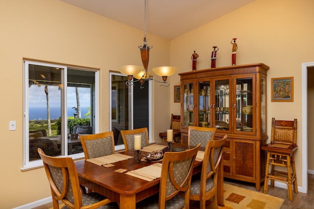 dining space with a chandelier, vaulted ceiling, and wood-type flooring