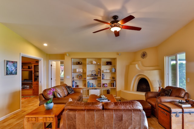 living room featuring lofted ceiling, light wood-type flooring, and ceiling fan