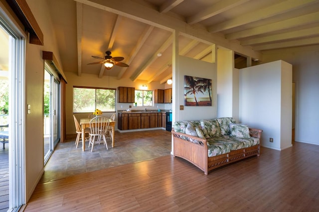 living room with vaulted ceiling with beams, dark hardwood / wood-style floors, sink, and ceiling fan