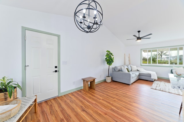 living room featuring light hardwood / wood-style floors, lofted ceiling, and ceiling fan with notable chandelier