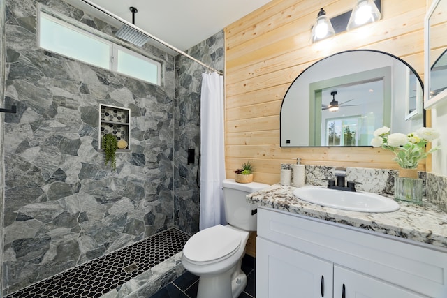 bathroom with toilet, wooden walls, walk in shower, vanity, and ceiling fan