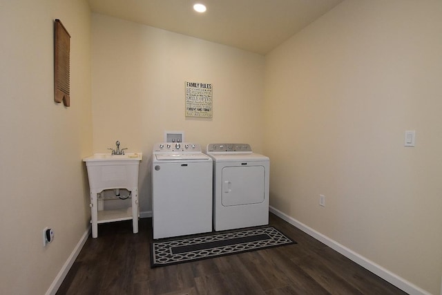 laundry area featuring dark hardwood / wood-style floors, washing machine and dryer, and sink