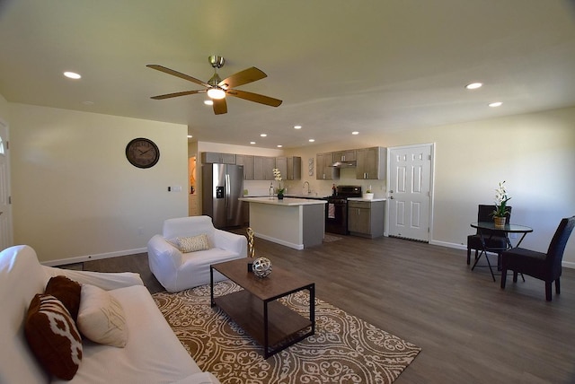 living room with ceiling fan, sink, and dark wood-type flooring