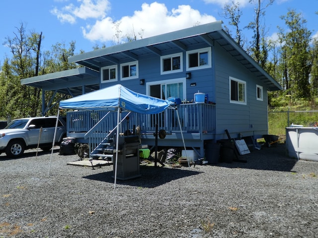 rear view of house featuring a wooden deck