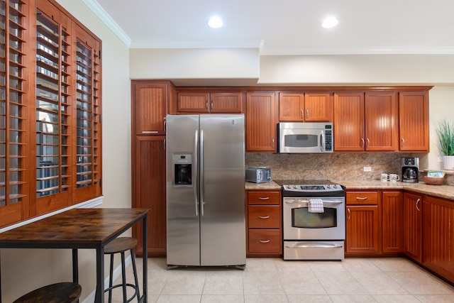 kitchen with light tile patterned flooring, crown molding, stainless steel appliances, light stone countertops, and decorative backsplash