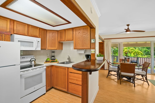 kitchen with sink, kitchen peninsula, white appliances, light hardwood / wood-style flooring, and decorative backsplash