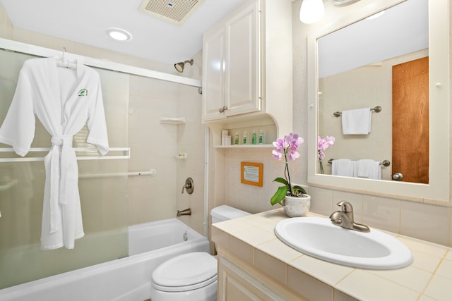 full bathroom featuring toilet, backsplash, vanity, and tiled shower / bath