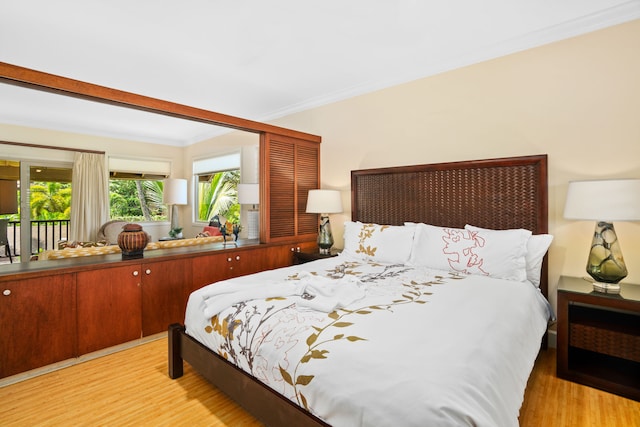 bedroom with access to exterior, light wood-type flooring, and crown molding