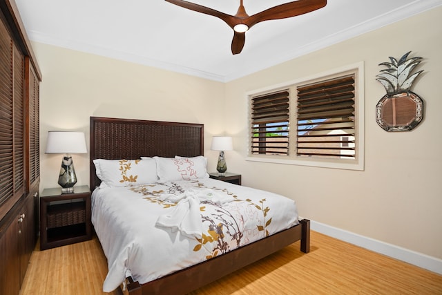 bedroom featuring ceiling fan, a closet, light hardwood / wood-style flooring, and crown molding