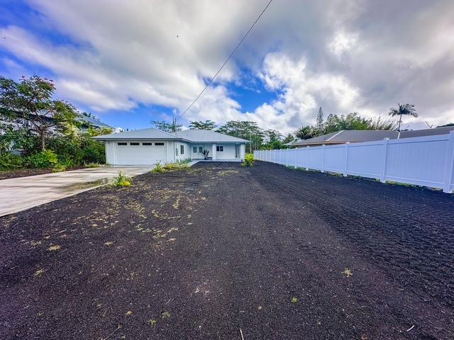view of front of property featuring fence, driveway, and an attached garage
