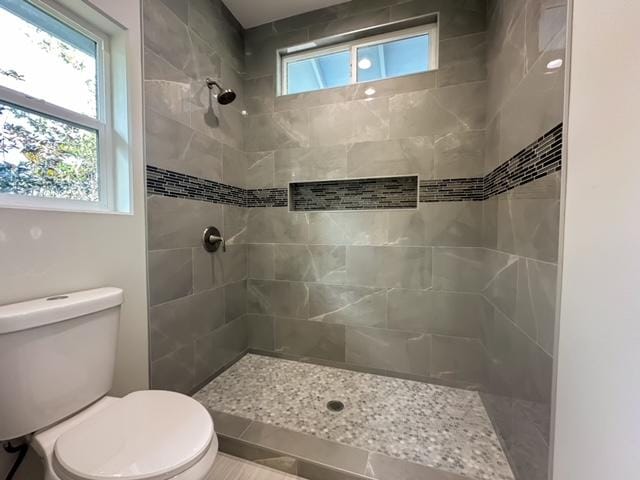 bathroom featuring toilet and tiled shower