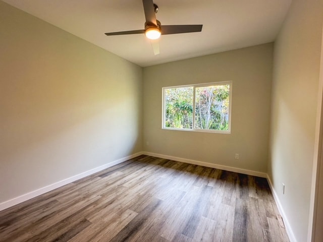 spare room with dark wood-type flooring and ceiling fan