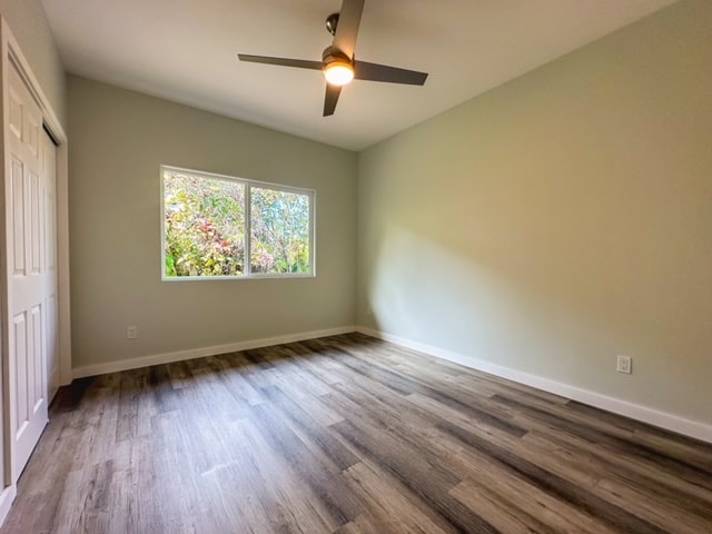 unfurnished bedroom featuring a closet, wood-type flooring, and ceiling fan