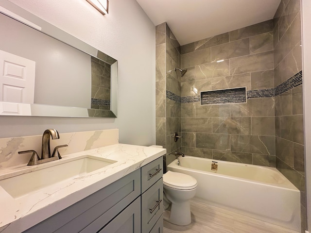 full bathroom featuring vanity, toilet, tiled shower / bath combo, and hardwood / wood-style floors