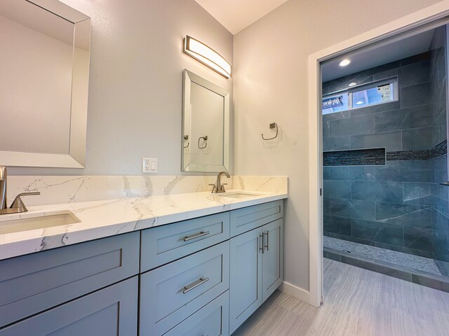 bathroom featuring vanity, hardwood / wood-style floors, and a tile shower