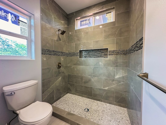 bathroom featuring toilet and a tile shower