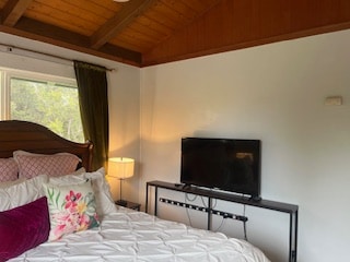 bedroom with wood ceiling and vaulted ceiling with beams