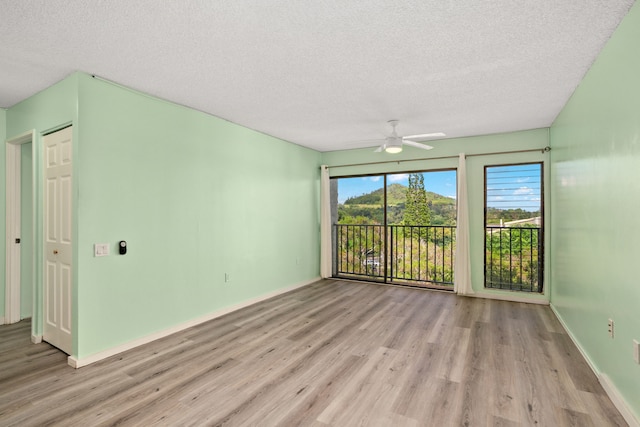 spare room featuring ceiling fan, a textured ceiling, and light hardwood / wood-style floors