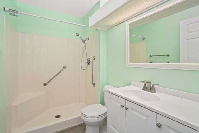 bathroom with toilet, a shower, vanity, and hardwood / wood-style flooring