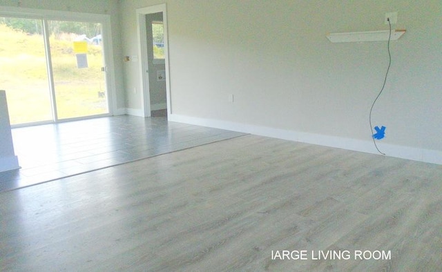 empty room with baseboards and wood finished floors