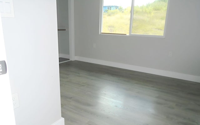 unfurnished room featuring baseboards and wood finished floors