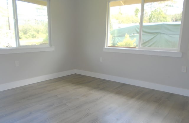 unfurnished room featuring a wealth of natural light and hardwood / wood-style flooring