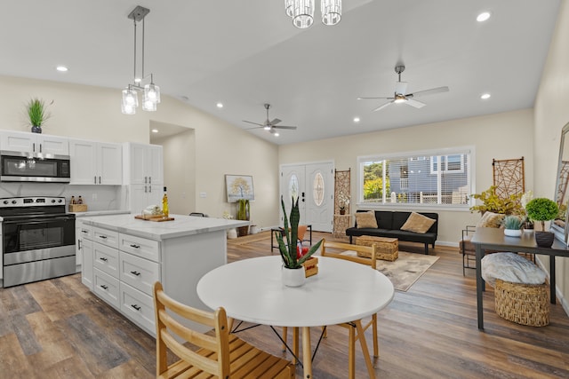 kitchen with dark hardwood / wood-style flooring, white cabinetry, stainless steel appliances, lofted ceiling, and pendant lighting