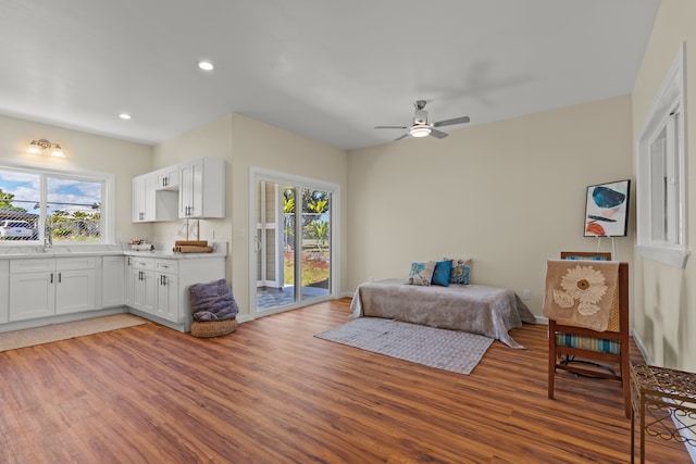 bedroom with hardwood / wood-style floors, access to exterior, and multiple windows