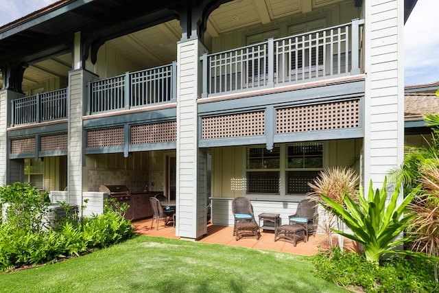 back of house with a patio area, a yard, and a balcony