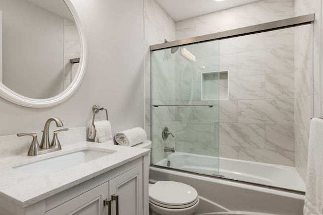 full bathroom featuring vanity, enclosed tub / shower combo, and toilet