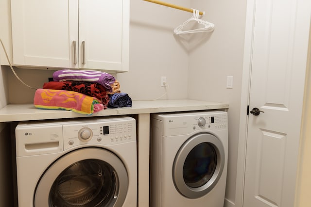 clothes washing area with cabinets and washing machine and clothes dryer