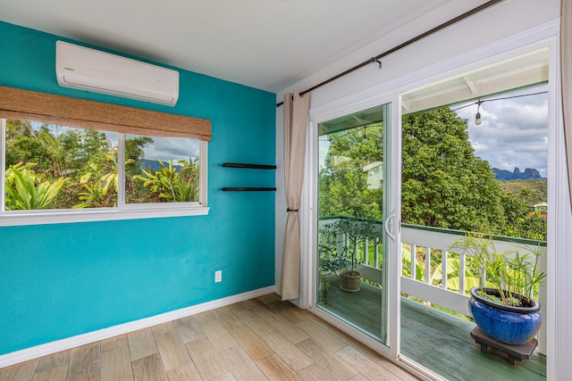 doorway featuring light hardwood / wood-style floors, an AC wall unit, and a wealth of natural light