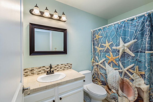 bathroom featuring decorative backsplash, toilet, walk in shower, and vanity