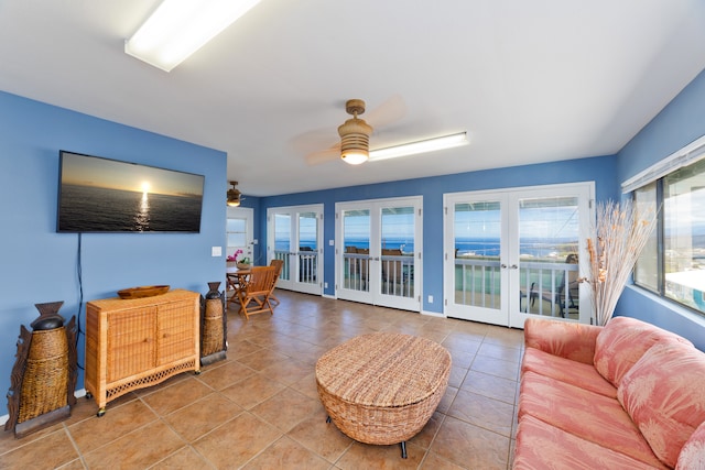 tiled living room with french doors and ceiling fan