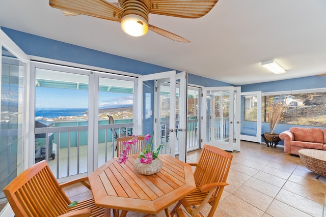 sunroom / solarium with french doors, a water view, and ceiling fan