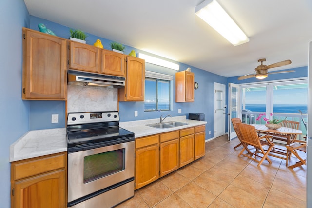 kitchen featuring sink, stainless steel range with electric cooktop, backsplash, ceiling fan, and light tile patterned floors